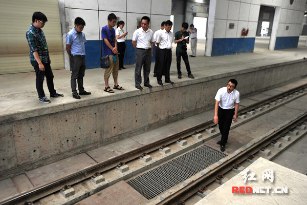 工作人員講解鐵路專用線設計的散裝散卸功能：運稻谷的列車停到這里后，底部的倉門打開，稻谷就會通過鐵道間的裝卸口進入地下的運輸系統，然后被抽高進入立筒式糧倉。