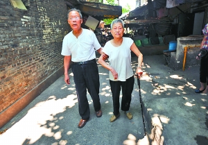 昨日，江北野水溝，92歲羅家強(qiáng)正扶著82歲老伴唐素芬散步鍛煉。 重慶晨報記者 李斌 攝